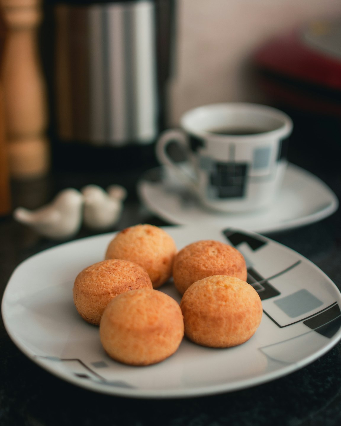 Golden-brown cheese bread rolls on a white plate.