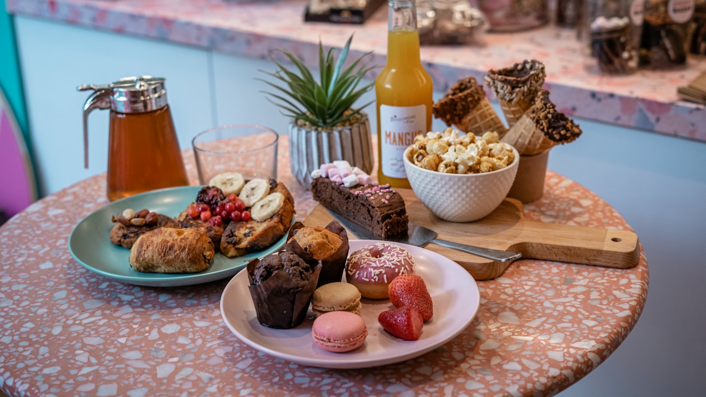 An assortment of snacks and desserts spread across a cafe table.